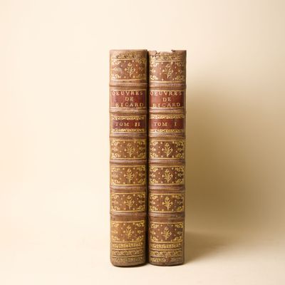 deux vieux livres posés l'un sur l'autre sur une surface blanche