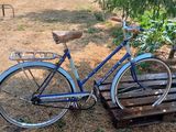 a blue bicycle that is parked on a wooden platform