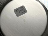 an image of a close up of a metal pan with a sticker on it