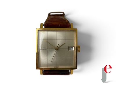 une montre posée sur une surface blanche