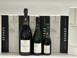 trois bouteilles de vin et une boîte de vin posées sur une table