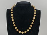 un collier en or sur un présentoir avec un mannequin noir
