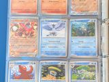 a lot of pokemon cards in a binder on the table