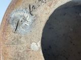 a brown vase with writing on it sitting on a table