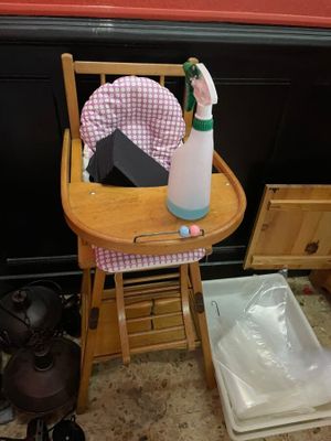 une chaise haute pour bébé sur laquelle sont posés une bouteille d'eau et un vaporisateur