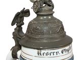a beer mug with a statue on top of it