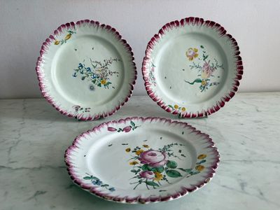 three plates with floral designs on them sitting on a table