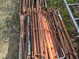 a pile of rusted metal pipes on the ground next to a ladder