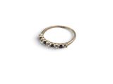 a gold ring with black diamonds on a white background