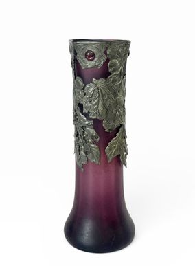un vase violet orné de feuilles sur fond blanc