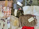 une valise pleine de vêtements, dont certains ont encore leurs étiquettes