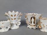 three white vases with gold designs on them on a gray surface