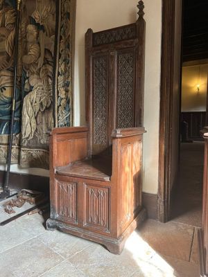 un banc en bois au milieu d'une pièce, avec une tapisserie accrochée au mur derrière lui