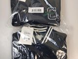 trois t-shirts noirs à rayures blanches sont emballés dans du plastique