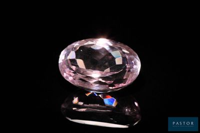 une image représentant un diamant rose posé sur une surface noire