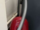 un aspirateur rouge dans un coin de la salle de bains