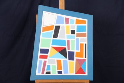 un chevalet sur lequel est posé un tableau représentant un motif géométrique coloré