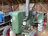 un tracteur vert garé dans une grange