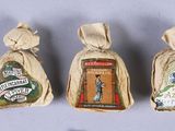 four miniature christmas ornaments are displayed in a row on a white surface