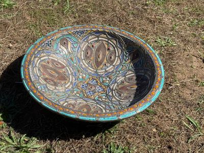 a bowl that is sitting on the ground in the grass