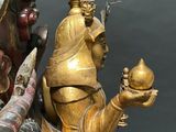 a gold statue of a man holding a ball