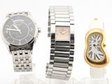 Deux montres et une montre en or sont posées sur une surface blanche