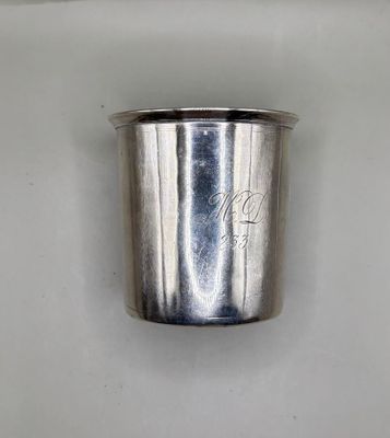 a silver cup that is sitting on a white surface