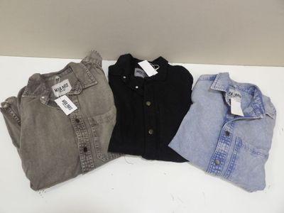 trois paires de chemises pour homme posées sur une table blanche
