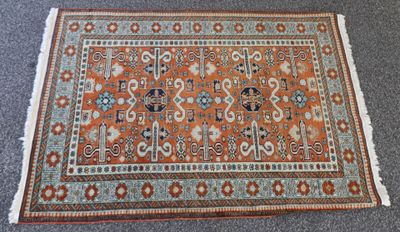 un tapis orange et bleu posé sur une moquette grise