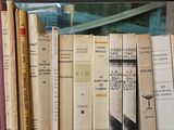 many books that are on a shelf next to a window