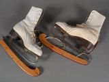 deux paires de patins à glace blancs posées sur une luge en bois