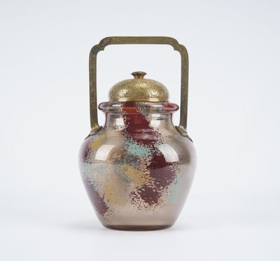 a glass jar with a handle on a white surface
