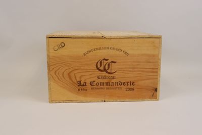 une vieille boîte en bois portant un logo, posée sur une surface blanche