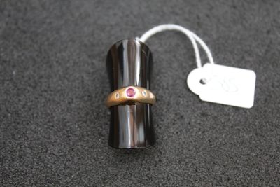 a ring with a pink stone on it sitting on a table