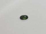 a green tourmaline stone on a white surface