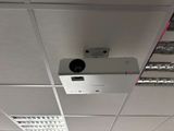 a projector mounted on the ceiling of a room