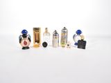 cinq flacons de parfum miniatures posés sur une surface blanche
