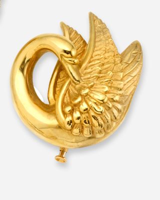 une paire de broches en forme de cygne de couleur dorée sur fond blanc