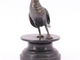 statue of a bird on a pedestal on a white background