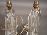 two clear glass lamps with gold trims on a gray surface