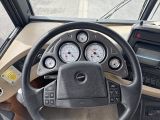 a steering wheel and gauges in the driver ' s seat of a bus