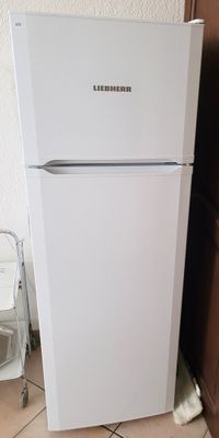 un réfrigérateur blanc dans le coin d'une cuisine