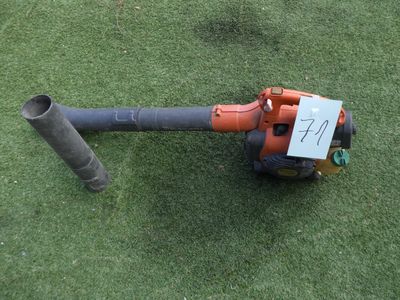 un petit souffleur posé sur l'herbe, avec une pancarte accrochée dessus