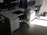 un bureau avec deux ordinateurs et une chaise dans une pièce