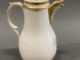 a white and gold coffee pot with a gold lid