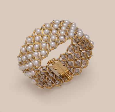 a close up of a gold bracelet with pearls and diamonds