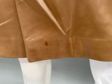 a close up of a mannequin wearing a tan leather skirt