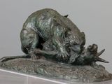 a bronze statue of a dog and a cat on a rock