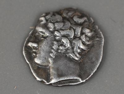 une vieille pièce d'argent portant une tête de femme