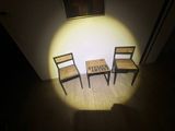 two chairs and a table in a room with a picture on the wall